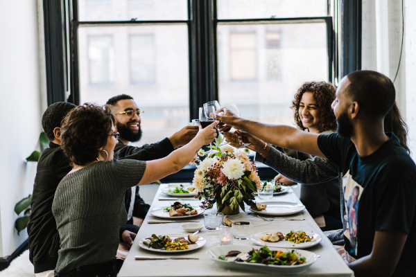 Group of friends toasting each other over dinner.